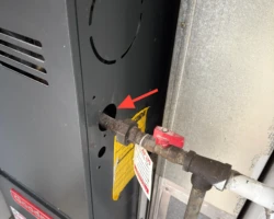Furnace Gas Line – Missing Bushing at the Cabinet Gas pipe entering a furnace cabinet through an unsealed opening with no bushing