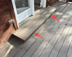 Narrow single concrete step serving an exterior door, far shallower than a proper landing