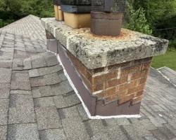 Masonry chimney rising only a short distance above the roof surface beside it