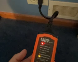 Plug-in circuit tester in a wall receptacle showing an incorrect wiring result
