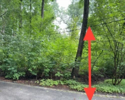 Overhead electrical service conductors hanging low across a residential driveway