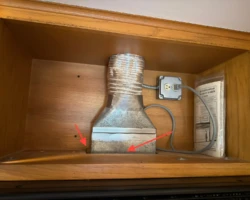 Gaps around an over-range microwave vent connection inside a kitchen cabinet
