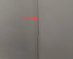 Hairline crack running through interior wall drywall finish