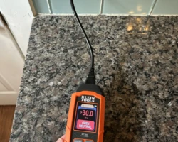 Plug-in circuit tester in a wall receptacle indicating an open neutral