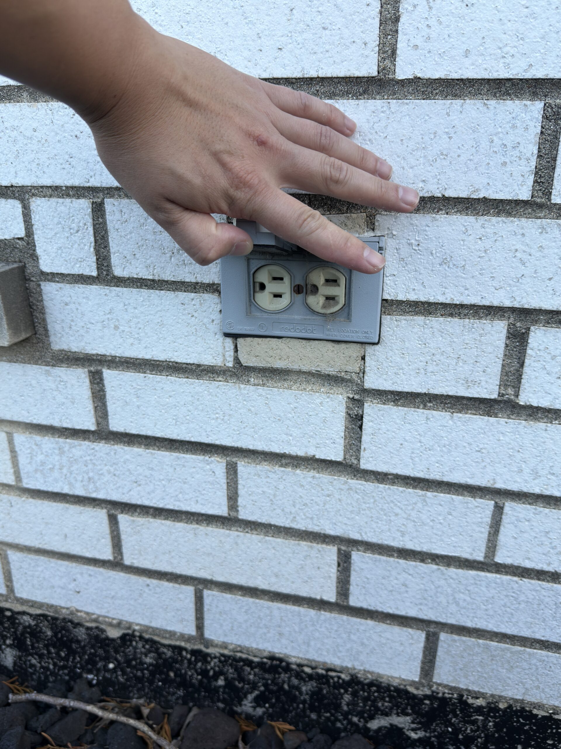 Standard non-GFCI receptacle mounted on the exterior wall of a house